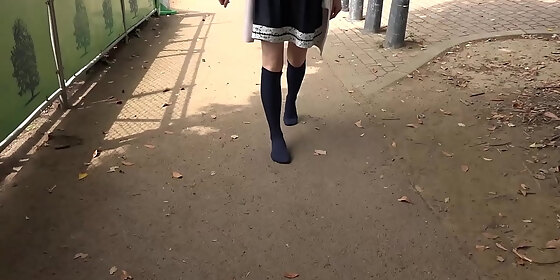 a girl walks on a dirt or sandy road with just socks without wearing shoes