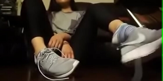 asian girl takes off her tennis shoes and socks