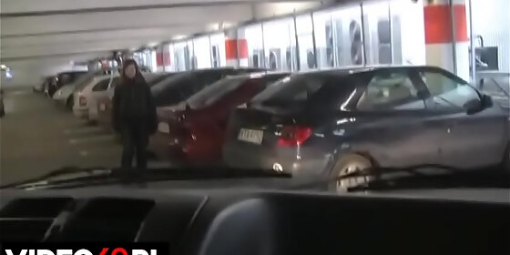 a h girl gives a blowjob in car on the parking lot of a shopping mall