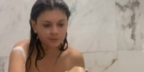 beautiful girl shaves her legs in the shower
