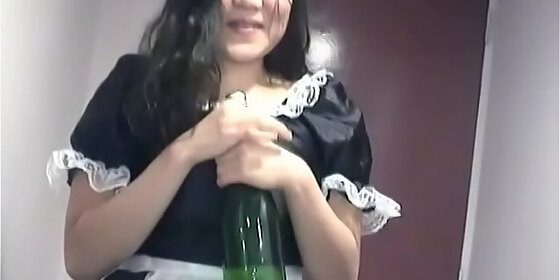 young asian girl dressed as a maid indulges herself with a bottle of champagne on camera for you